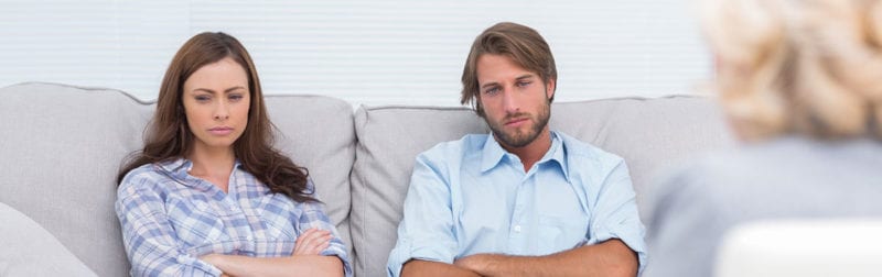 Divorce Mediation; couple sitting on a couch upset talking to mediator 