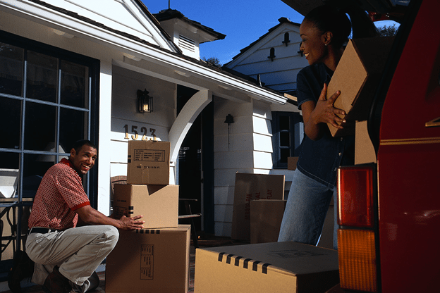 Young black couple loading moving boxes into van