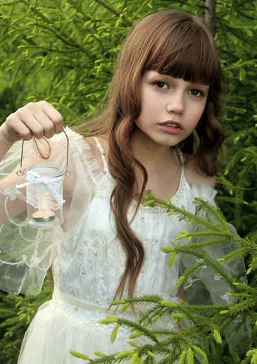 young girl in wedding dress outside