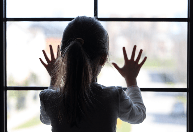 young girl looking out window